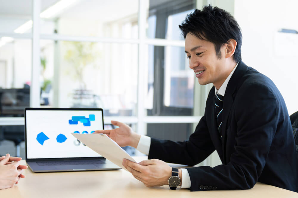 資料を説明する営業マン